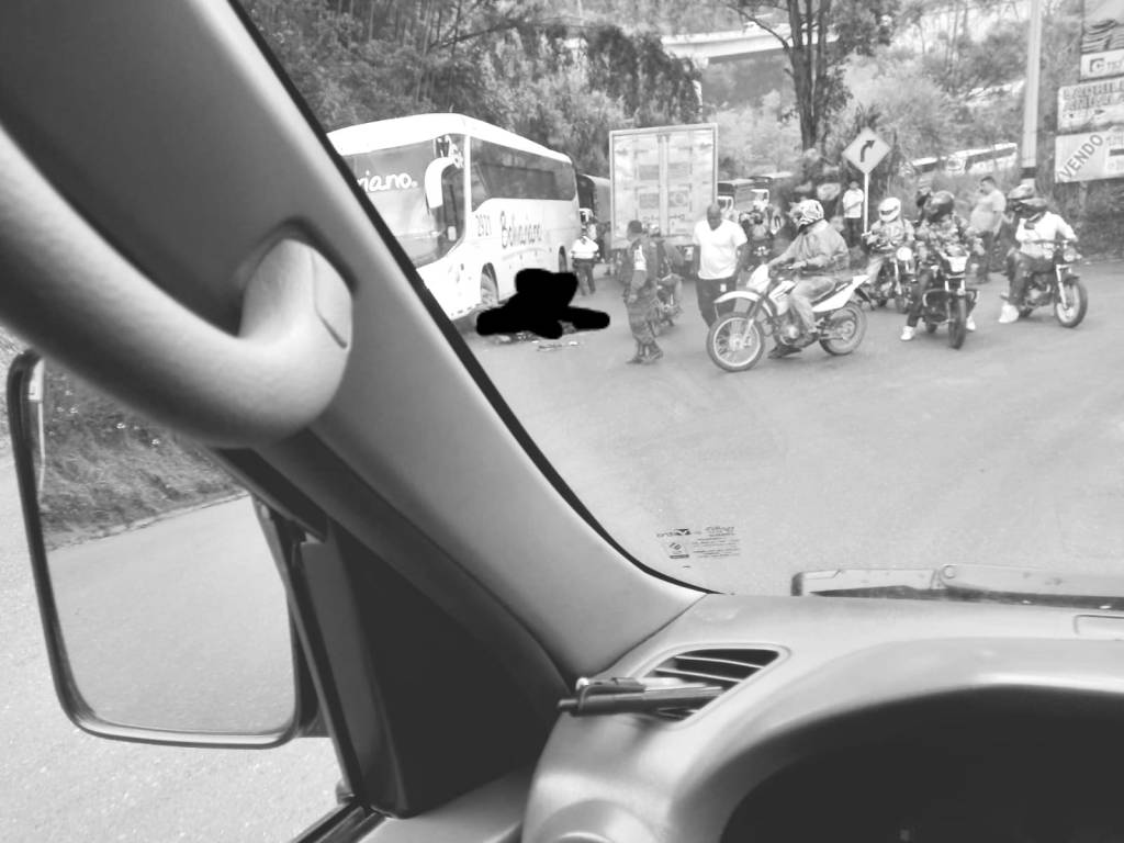 motociclista queda entre un camión y un bus